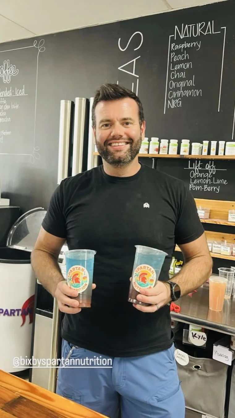 Jon Henthorn holding two Spartan Nutrition drinks inside the Bixby club